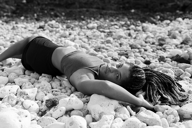 Jhia Jackson lying on rocks