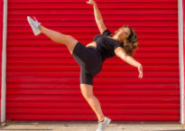 Amy Marie doing an extension in front of a red garage