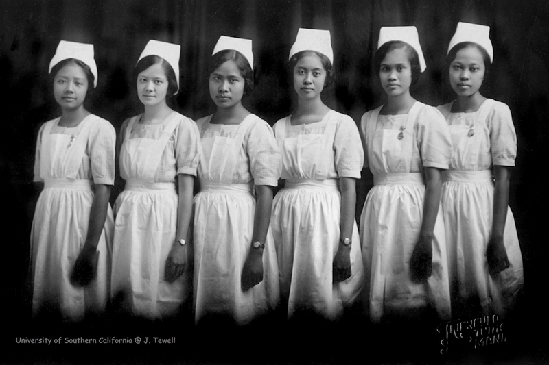 A line of seven nurses standing and staring forward.