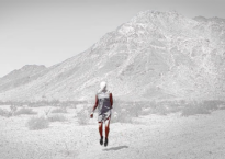 An image of a person walking in a barren Southwest landscape.