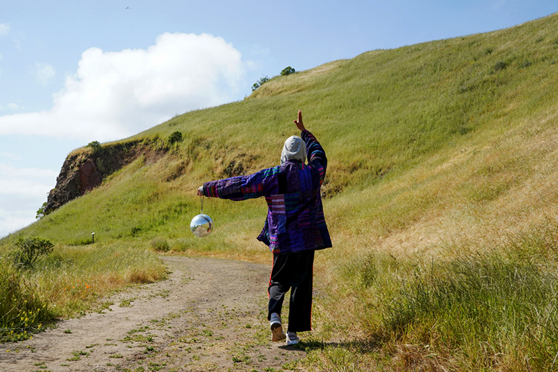estrella/x holding a disco ball on a hillside
