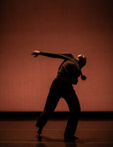 Karla Quintero dancing with orange background
