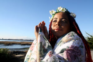 Andrea wrapped in a shall with a blue sky behind her.