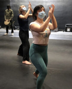 Two students lunge forward and clasp their hands in front of their faces.