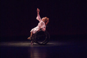 Mary Verdi-Fletcher in profile with one arm uplifted.