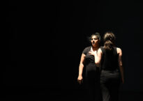 Two dancers in a spotlight.
