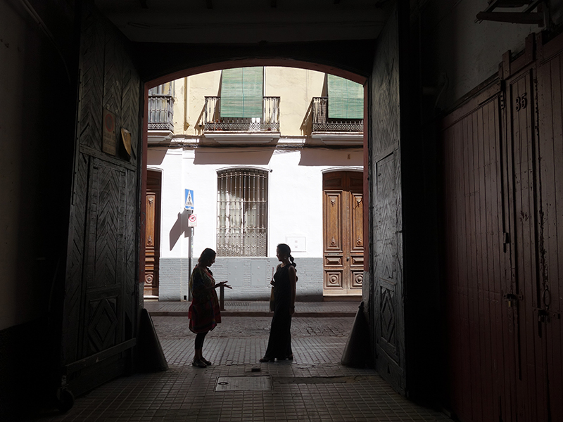 Two silhouettes of figures dance in a doorway.