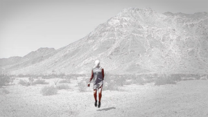 An image of a person walking in a barren Southwest landscape.