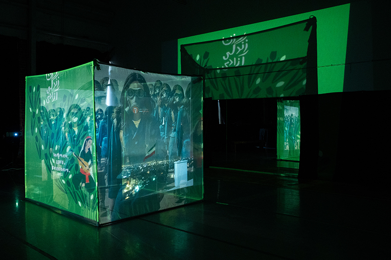 A large green cube with projected images on it.