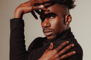 Omari Wiles makes gestures around his face.