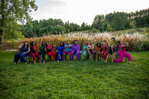 A group photo of dancers posing on grass