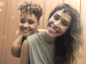 Sarah and Kai smile and lean into the camera.