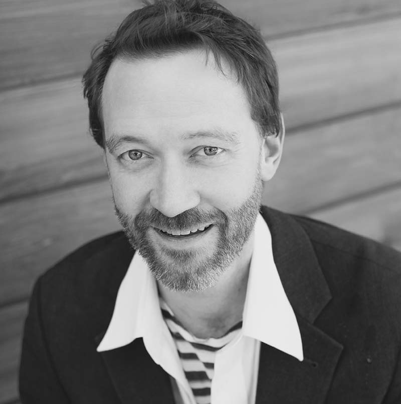 A black and white headshot of John