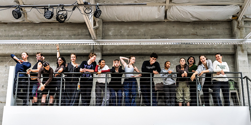 The Training Ground SF students stand in a balcony inside a dance studio, smiling and posing.